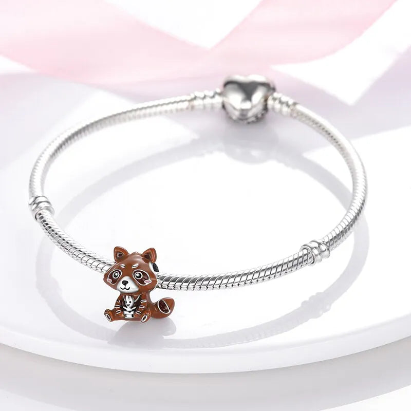 playful brown raccoon charm