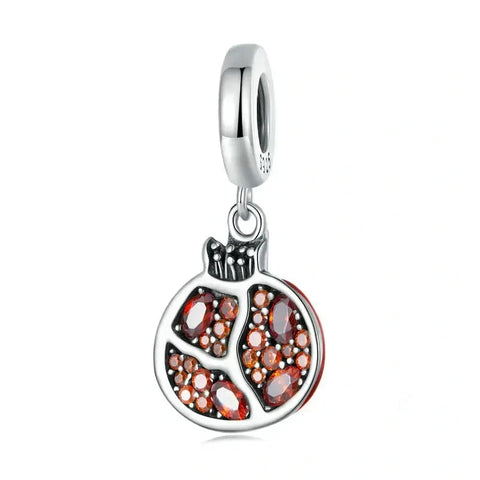 Silver pomegranate charm with red stones.