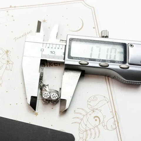 Baby carriage charm being measured.