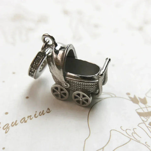 Silver baby carriage charm.