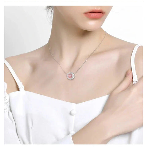 Silver necklace with pink gemstone pendant.