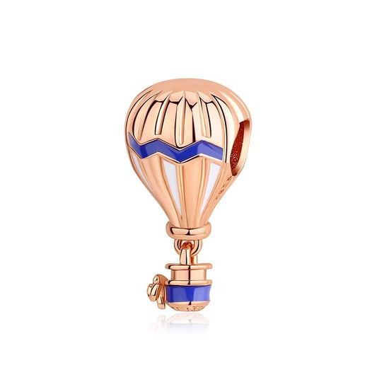 A rose gold-toned hot air balloon charm with blue and white enamel chevron accents and a miniature basket, designed as a clip-on charm for bracelets