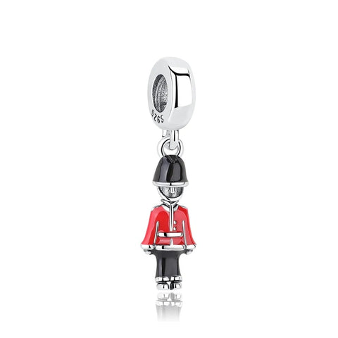 Sterling Silver Royal Guard Soldier Dangle Charm - A sterling silver dangle charm depicting a miniature British Royal Guard soldier with a black bearskin hat and red enamel tunic, attached to a silver clip bail