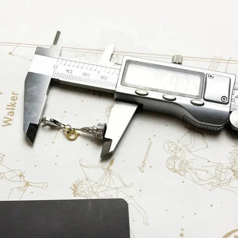 Digital caliper measuring a charm.