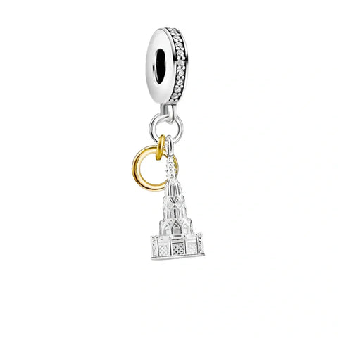 Silver charm with a building and gold ring.