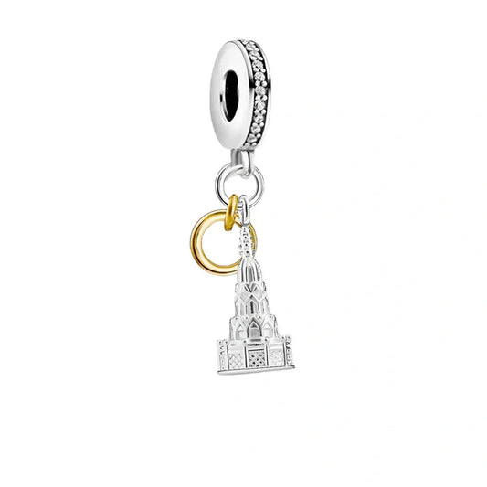 Silver charm with a building and gold ring.