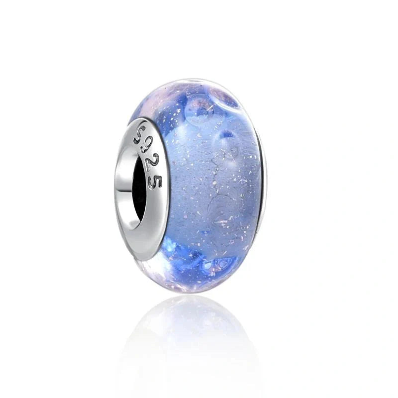 Sterling silver charm with shimmering blue glass for a soft and radiant look.