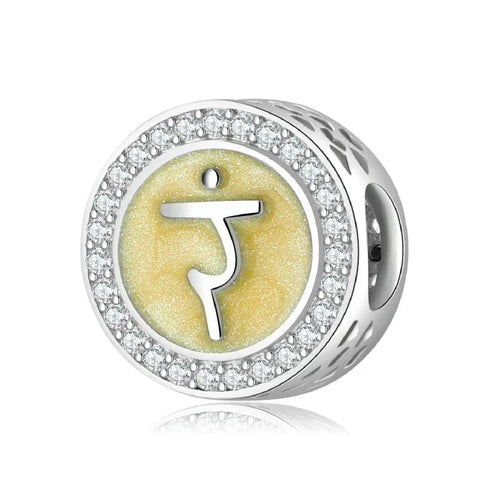 Silver charm with yellow symbol and crystal accents.