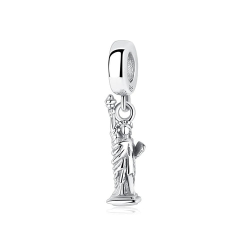 A sterling silver dangle charm shaped like the Statue of Liberty, with raised torch and flowing robes, hanging from a smooth S925 bail bead
