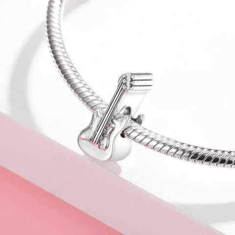 Silver guitar charm on a bracelet.