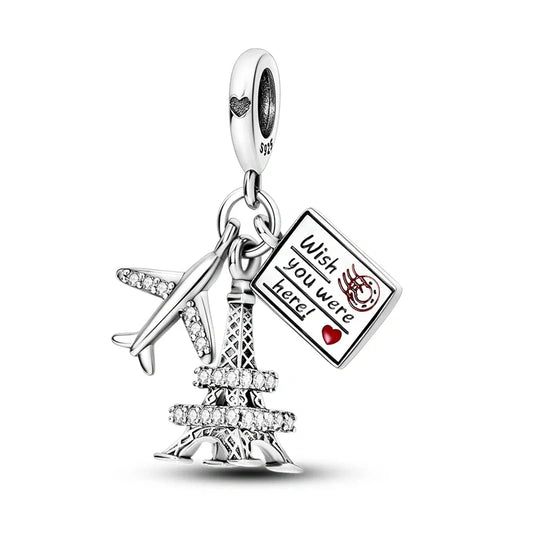 Sterling silver Eiffel Tower charm with airplane and postcard reading Wish you were here, perfect for Paris lovers and travelers.