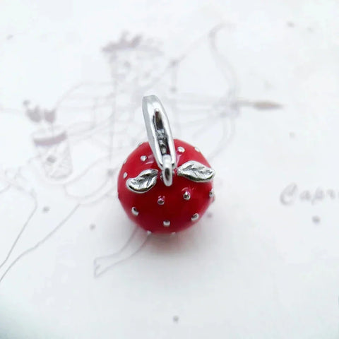Red strawberry charm with silver accents.