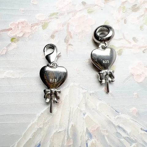 Two silver heart-shaped charms.