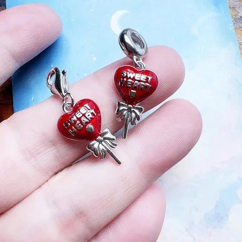Red heart-shaped lollipop charms.