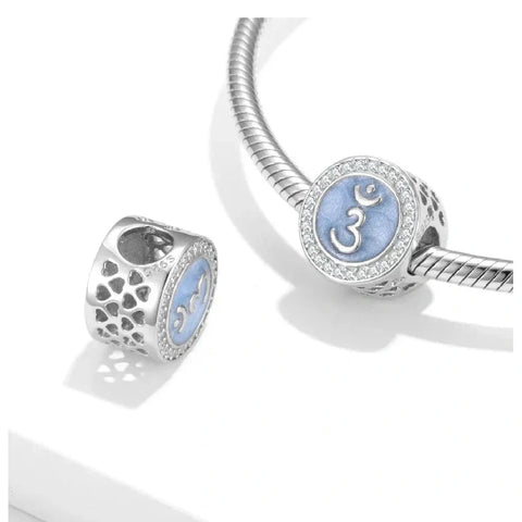 Silver charm with blue Om symbol.
