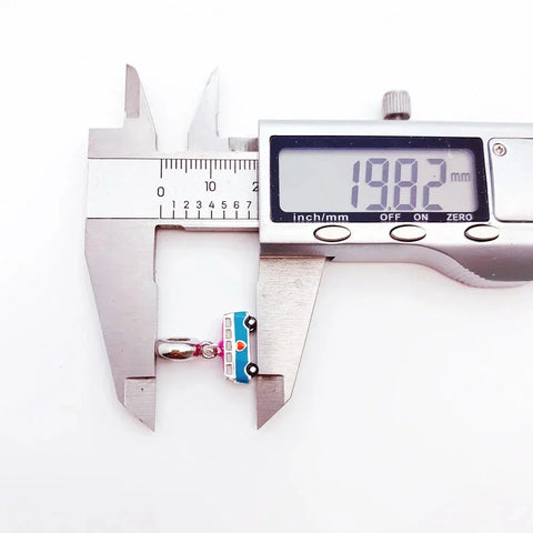 Digital caliper measuring a charm.