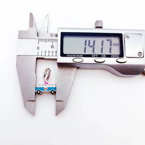 Blue bus charm measured by calipers.