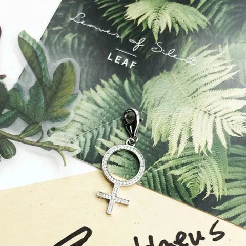Silver-tone female symbol charm.