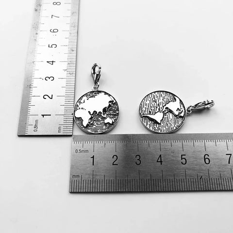 Two silver world map pendants.