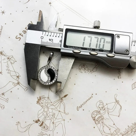 Yin-yang pendant being measured.