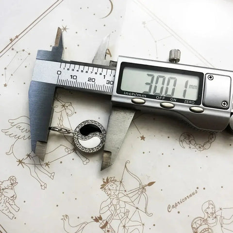Yin and yang pendant being measured.