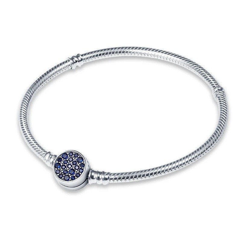 Sterling silver bracelet with a round charm encrusted with deep blue stones.