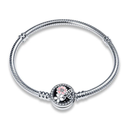 Sterling silver bracelet with a floral charm adorned with sparkling stones and pink enamel.