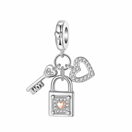 Silver charm with heart-shaped key, padlock, and heart, adorned with cubic zirconia.