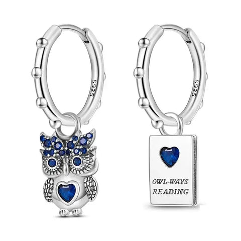 Sterling silver owl charm earrings with blue cubic zirconia stones.
