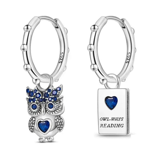 Sterling silver owl charm earrings with blue cubic zirconia stones.