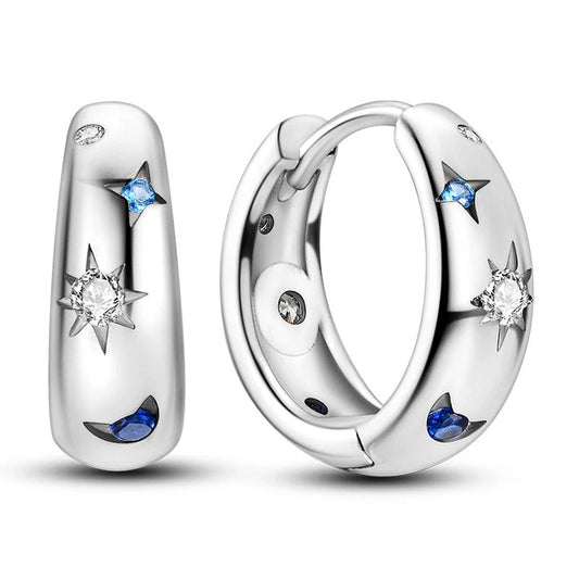Sterling silver hoop earrings with star and moon designs with blue accents.