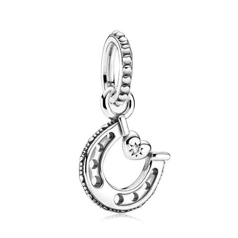 Silver lucky horseshoe charm with a heart and cubic zirconia, perfect for adding a touch of luck.